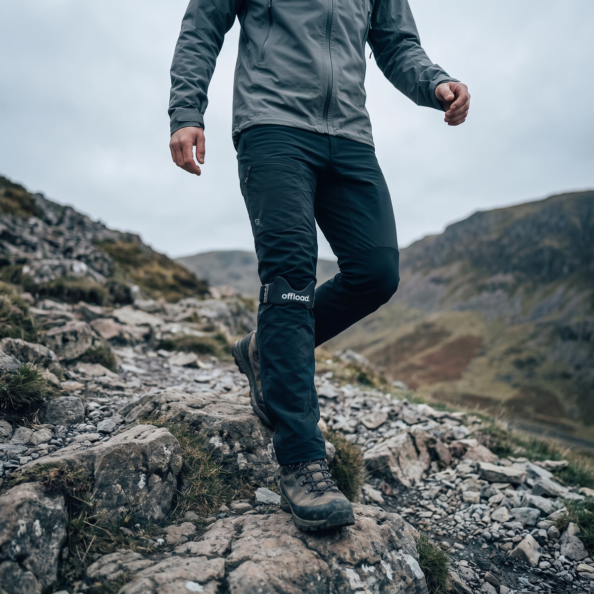 Hiker wearing the offload. knee strap descending a rocky mountain trail, square crop