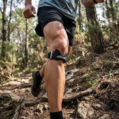Runner wearing the offload. knee strap on a trail run